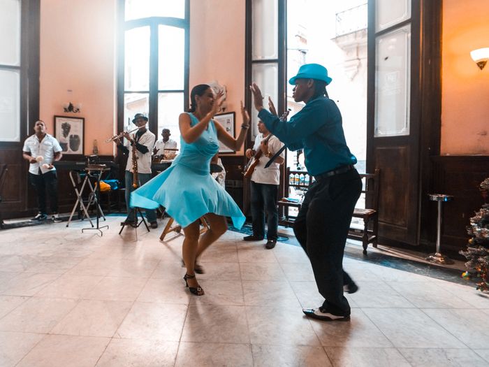 Bailarines practicando juntos en una sala de luz cálida